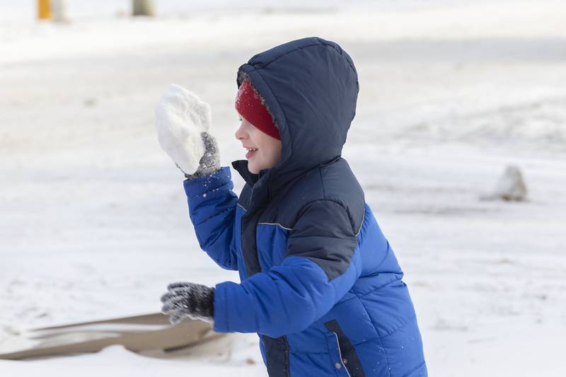 Zayden Lyerla takes time for a snowball fight while helping dad deliver gifts Saturday, Dec. 24, 2022.