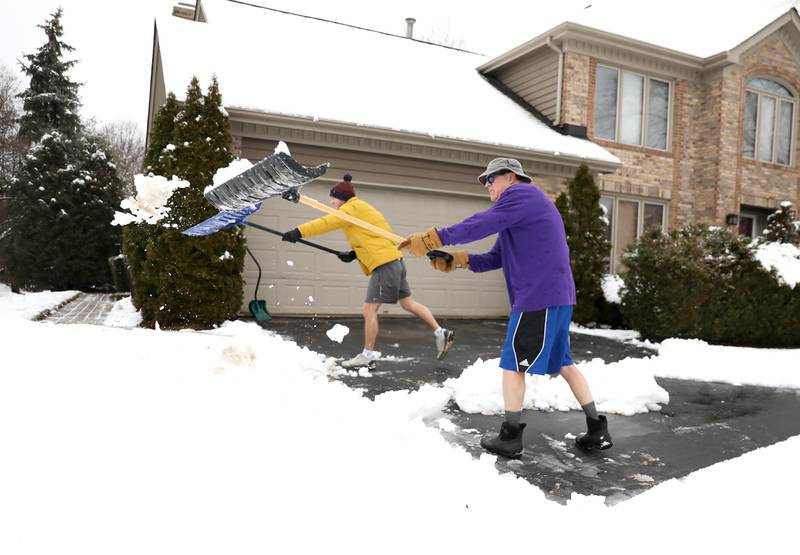 James (right) and Dylan Carroll shovel their Geneva driveway after an overnight snowfall on Tuesday, Jan. 9, 2024.