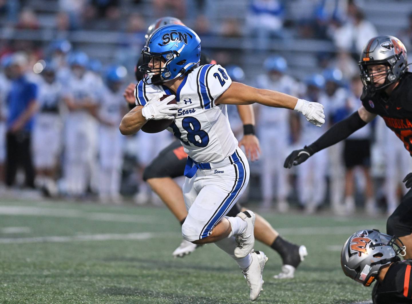 St. Charles North's Carsen Durante (28) rushes for a big gain during the non-conference game against Minooka on Friday, Aug. 29, 2025, at Minooka.
