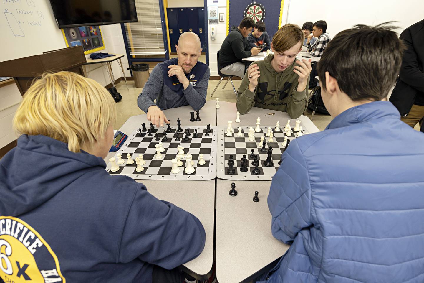 Sterling High School chess instructor Joel Penne plays a team chess game with some of his students during an off season activity hour at the school.