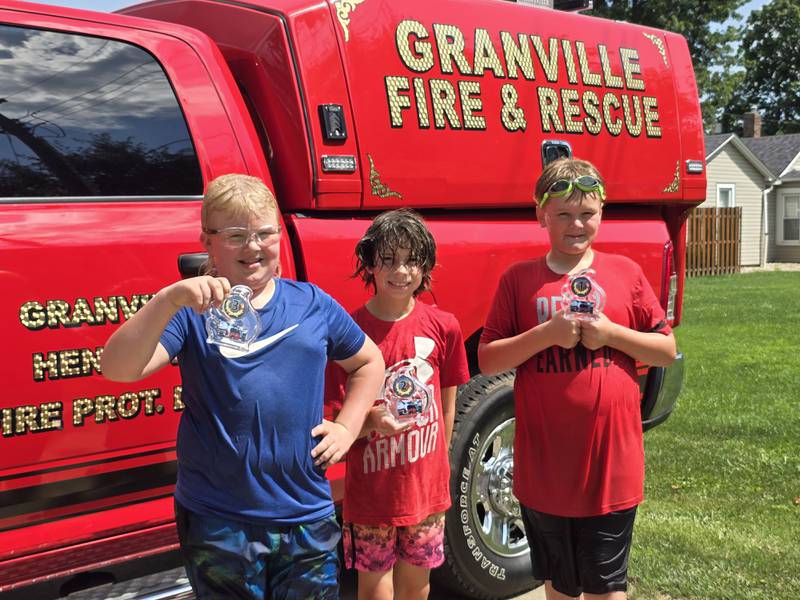 (From left) Bryce Burris (third), Gunner Perino (second) and TJ Kramarsic (first) show off their trophies Saturday, Aug. 3, 2024, from the water fights during Granville Days in Hopkins Park.