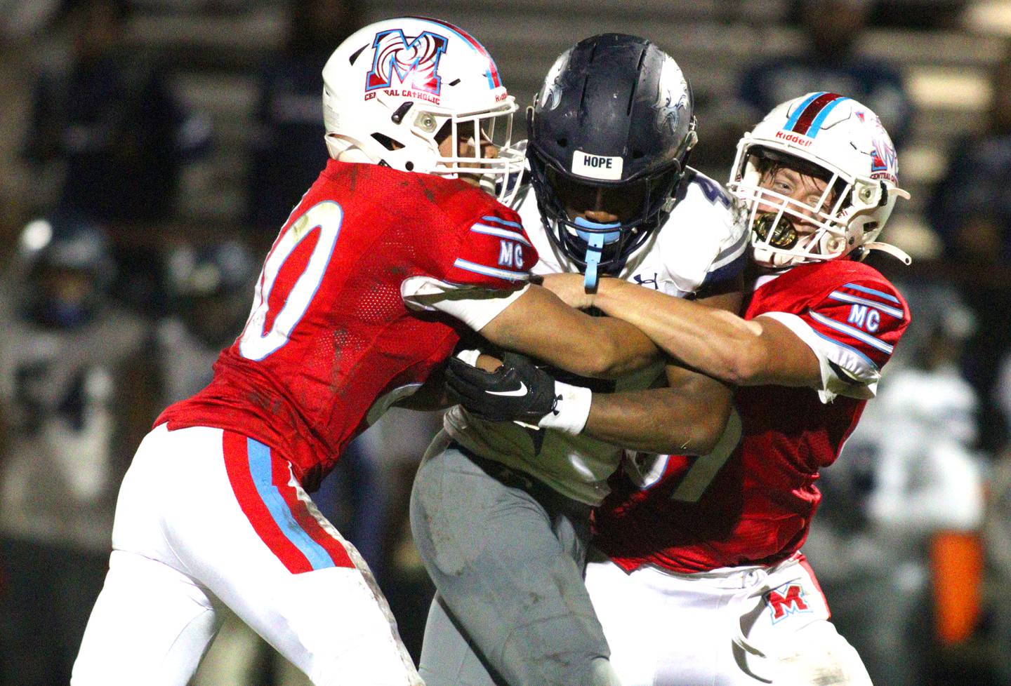 Marian Central’s Abel Arce, left, and Sam Mahoney, right, tackle Chicago Hope’s Jamari West  in varsity football at Woodstock Friday night.