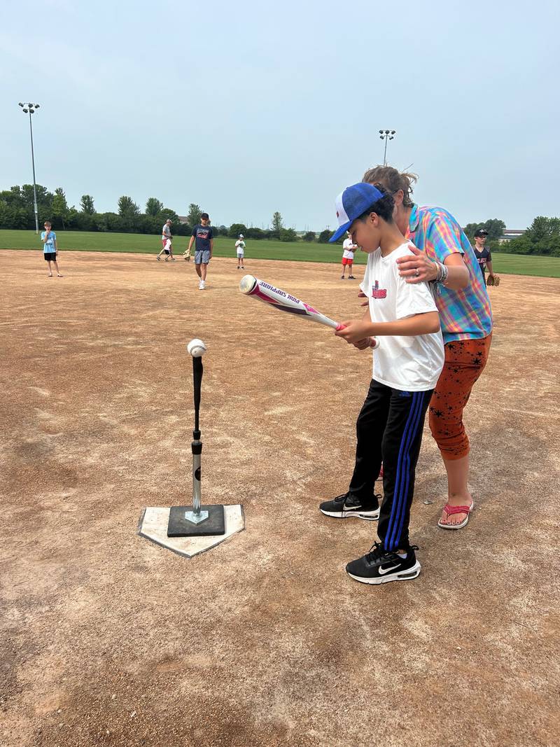 Algonquin Area Youth Organization Twisters baseball player Michael Swift swings the bat with assistance by Ryan O’Reilly during the team's first game on July 13, 2025.