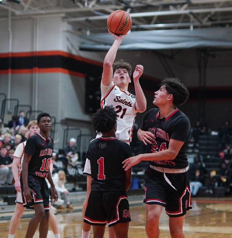 St. Charles East's Jacob Vrankovich (21) shoots a floater over East Aurora's Jaheim Wilkins (1) and Luis Umana (24)during the 64th annual Ron Johnson Thanksgiving Basketball Tournament at St. Charles East High School on Monday, Nov 20, 2023.