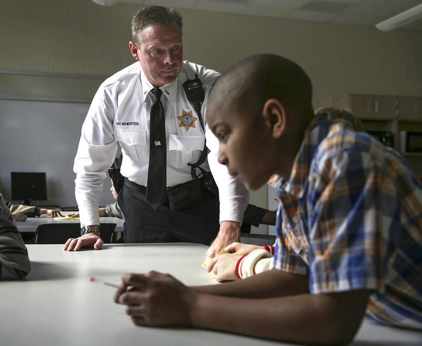 Officer Dennis McWherter in 2016 speaks to a table of students during a team building exercise at Isaac Singleton Elementary School in Joliet.