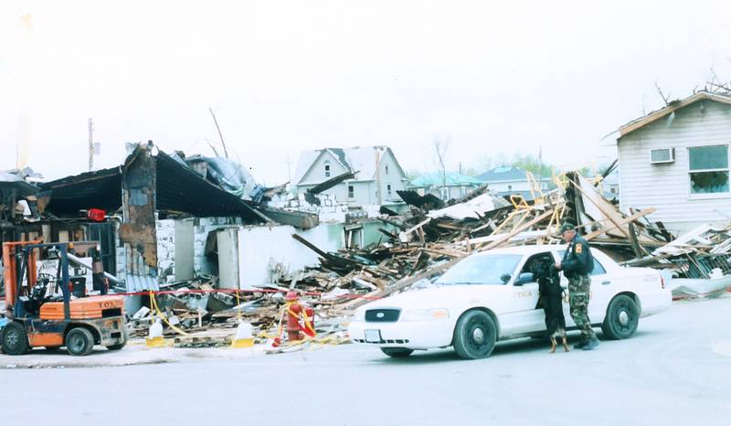 Former Utica K-9 police officer Jerry Nanouski and K-9 dog Bart survey the tornado damage on Wednesday, April 21, 2004 downtown Utica.
