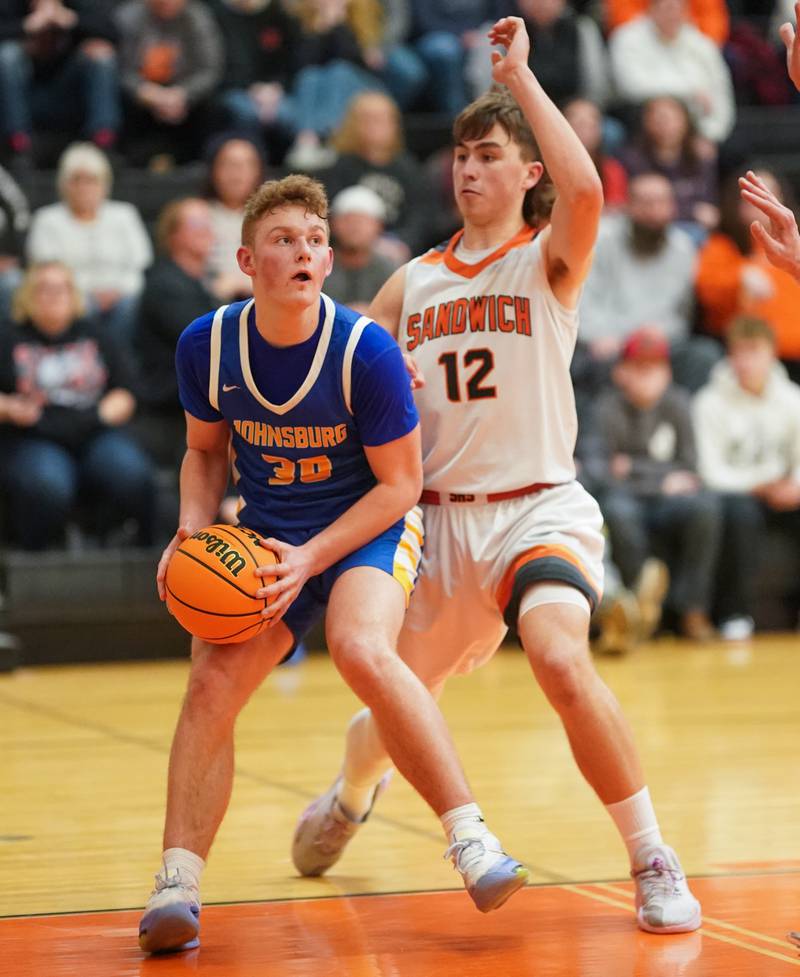 Johnsburg's Jayce Schmitt (30) posts up against Sandwich’s Braden Behringer (12) during a basketball game at Sandwich High School on Friday, January 31, 2025.