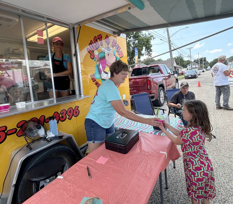 Nancy Tegeler of Just 4 Fun ice cream of Polo serves a rainbow sherbet cone to Lydia Slicer, 6, of Geneva, at Forreston's Sauerkraut Days on Saturday, Aug. 3, 2024.