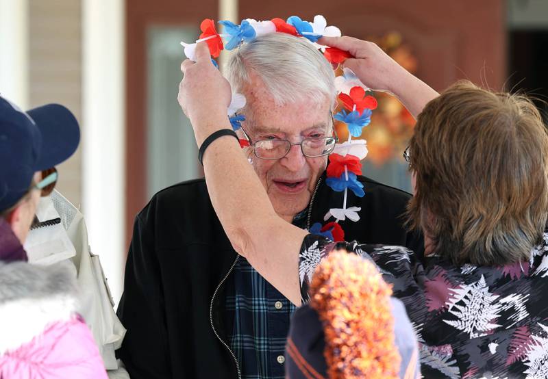 Ken Cooper, 96, a US Army veteran, receives a lei after members of the Kunkel family put on a small bike parade on Veterans Day,  Friday, Nov. 11, 2022, at the Grand Victorian assisted living facility in Sycamore. Sycamore resident Joann Kunkel read a story in the current Midweek that contained a quote from one of the veterans at the facility that lamented the lack of a parade. So she and her grandkids decided to have one for them.