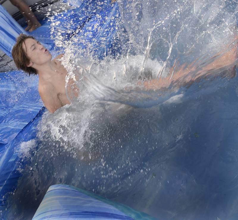 Cameron Ingram makes a big splash as he hits the bottom of an inflatable water slide Tuesday, Aug. 1, 2023, at the Marseilles Pool during National Night Out.