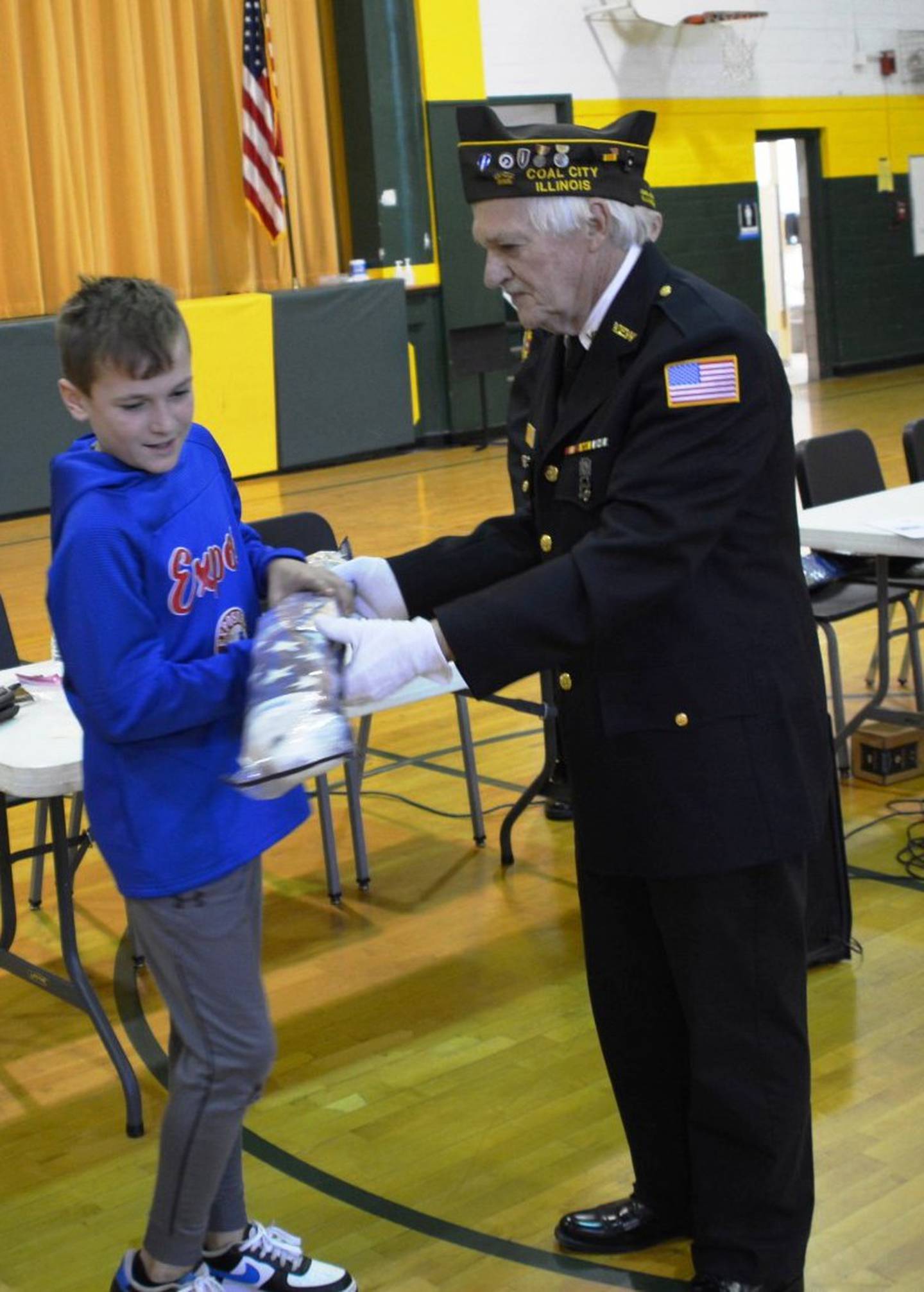 Andrew Becker receives his flag kit from Adjutant and Quartermaster Keith Roseland.