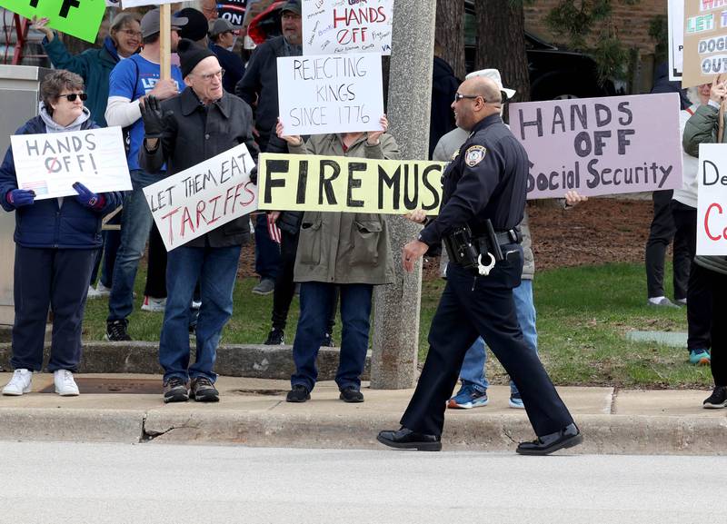 DeKalb Police Chief David Byrd makes sure people stay off of the road Saturday, April 5, 2025, as hundreds of people assembled for a Hands Off! rally at Memorial Park on the corner of First Street and Lincoln Highway in DeKalb. The group gathered to protest against various policies of President Donald Trump and his administration.