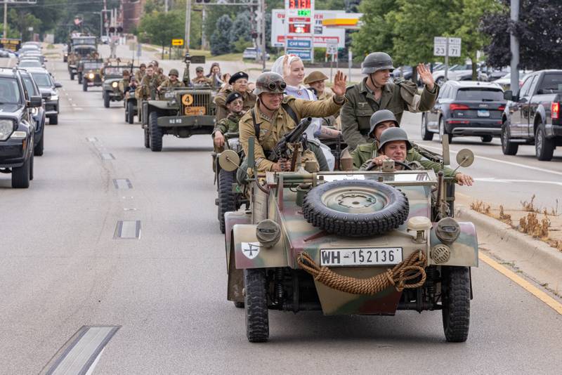 Members of the military convoy parade wave to onlookers on Columbus Street as part of the Ottawa Military Show on July 12, 2025 in rural Ottawa.
