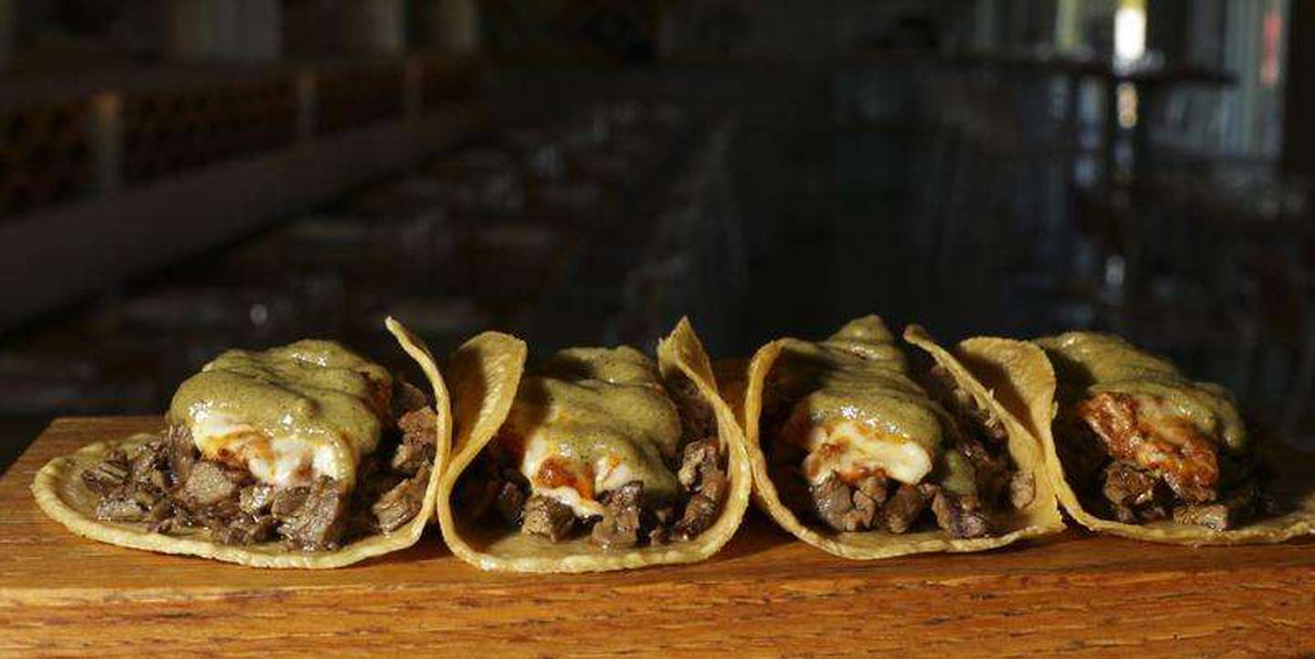 The Bien Trucha tacos are topped with melted chihuahua cheese at Naperville’s Quiubo.