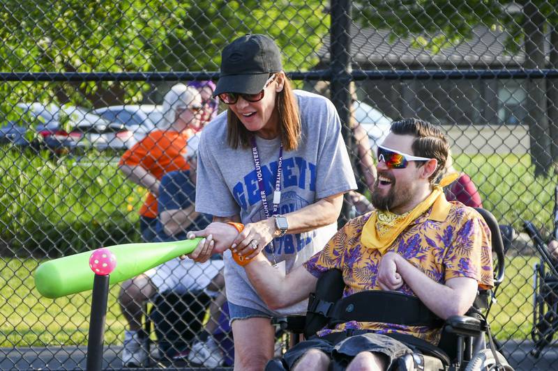 A volunteer assists a resident of Marklund Hyde Center near Geneva in a T-ball game. New volunteers are welcome to help out with summer baseball games.