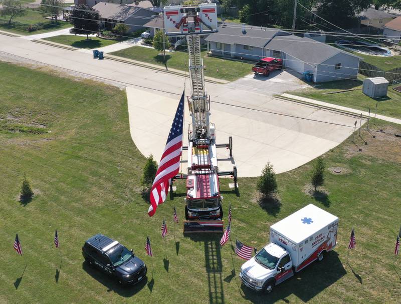 A Peru police car, firetruck and ambulance fly an American flag near the roundabout for a September 11th Memorial on Thursday, Sept. 11, 2025 in Peru.