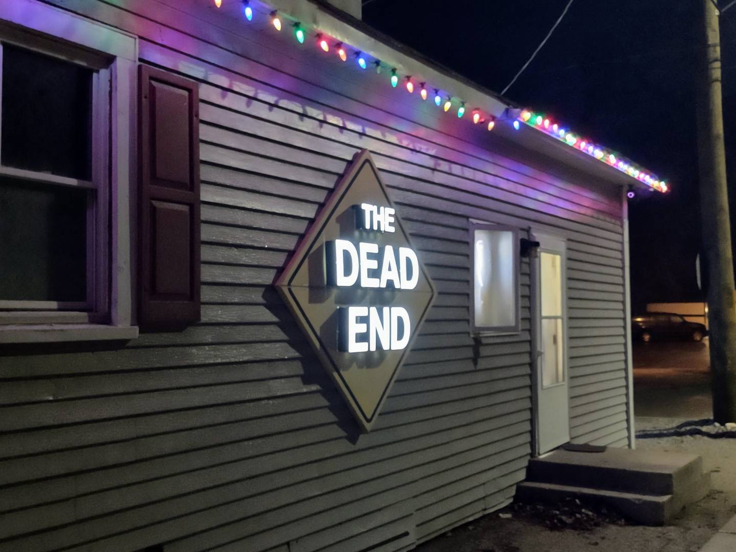 The unassuming entrance to the Dead End Bar & Grill, along with signage.