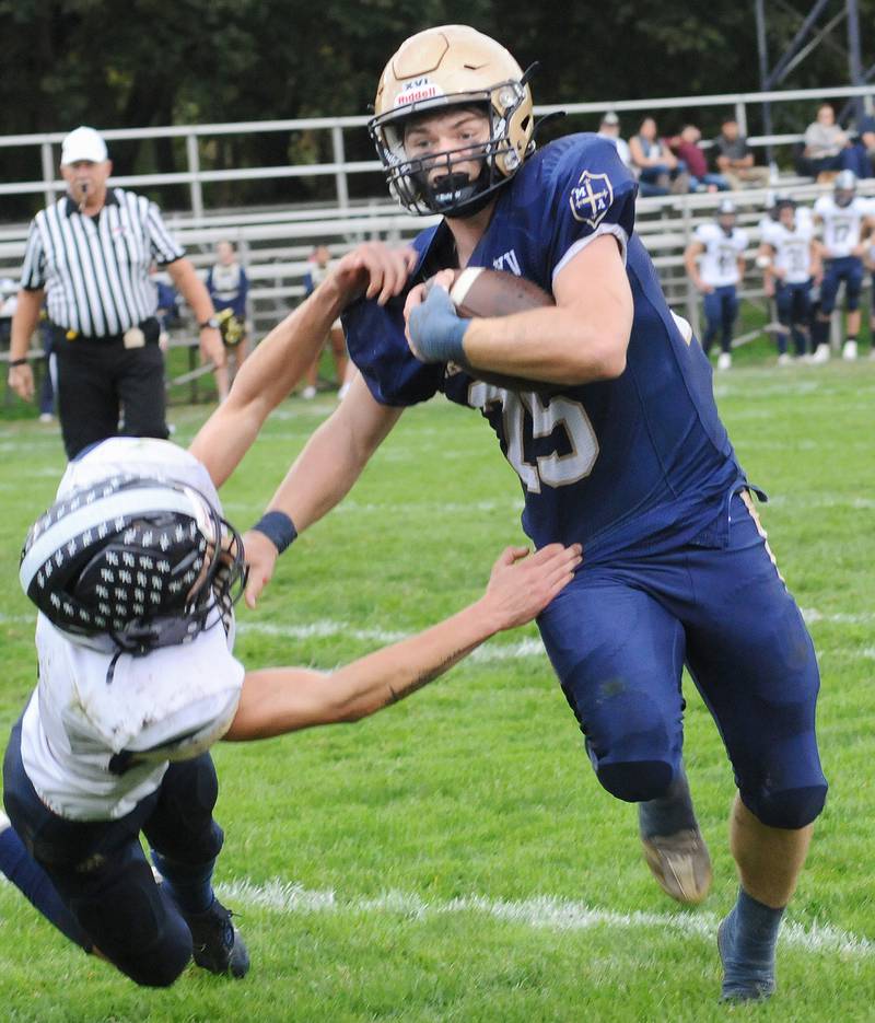 Knoxville’s Bradley Cummings tries to bring down Marquette’s Jaxsen Higgins on a run during the 2nd quarter Saturday at Marquette.