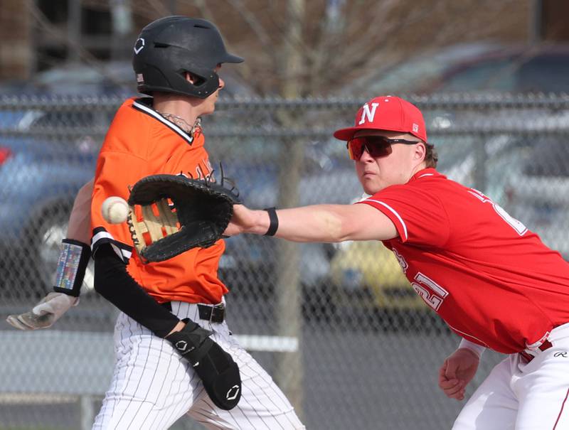Naperville Central's Troy Kashul has to reach around DeKalb's Jackson Kees to make the catch on a pickoff attempt Monday, April 28, 2025, during their game at DeKalb High School.