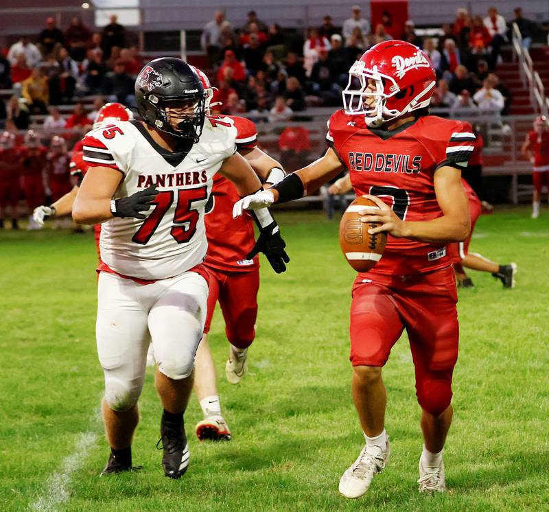 Hall's #7 Dylan Glenn looks to get rid of the ball before EP's #75 Caleb Reymer can take him down. The Panthers defense kept the hosting Red Devils scoring to a  minimum in the Friday night contest, allowing the Red Devils to score only 7 points to the Panthers 19.