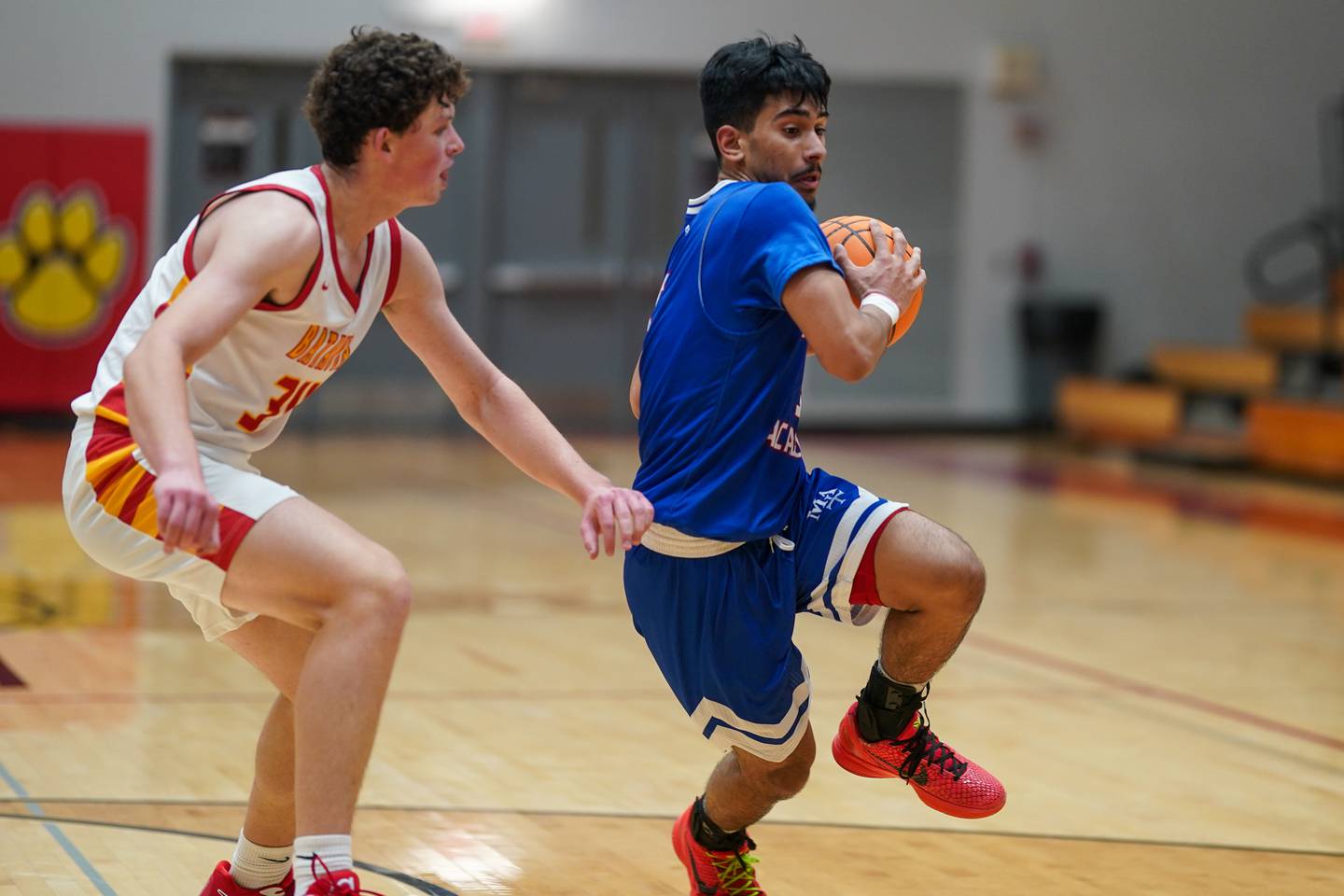 Batavia’s Payton Wolff (34) defends the paint against Marmion's Ali Muhammed Tharwani (5) during a basketball game at Batavia High School on Wednesday, Nov. 27, 2024.