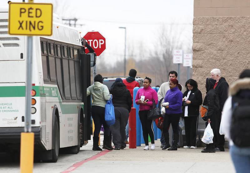 Passengers exit the TransVAC Green Line bus at the Wal-Mart stop as a line of passengers await their turn to board the bus Monday in DeKalb.