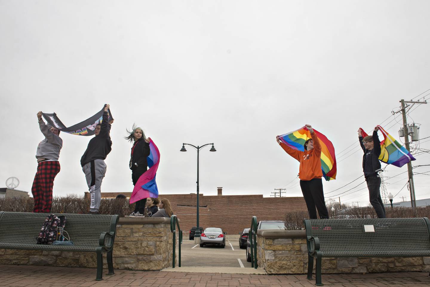 Nikelle Bassford (left), 18, Sky West, 16, Emily Allen, 16, Bailey Bramm, 16 and Kayden Carter, 15, display gay pride flags and chants as a show of disdain at the assault of Carter early this week at Dixon High School.