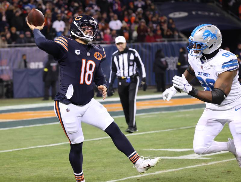 Chicago Bears quarterback Caleb Williams throws on the run as he is pursued by Detroit Lions linebacker al-Quadin Muhammad during their game Sunday, Jan. 4, 2026, at Soldier Field in Chicago.