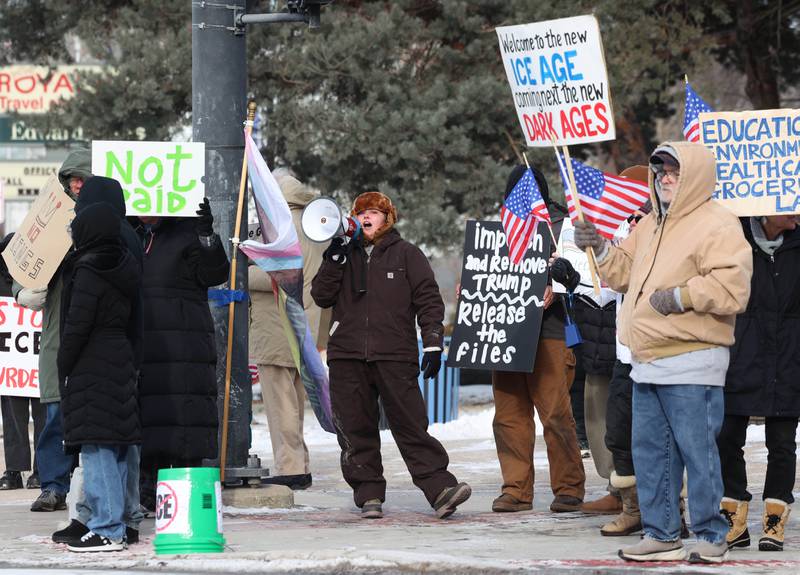 Protesters chant and carry signs Tuesday, Jan. 20, 2026, at Memorial Park on the corner of First Street and Lincoln Highway in DeKalb as part of a national Free America Walkout. The group is protesting what they perceive as an escalating fascist threat under President Donald Trump and his administration.