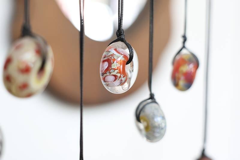 Several glass pendents created by Angelica Cristal hangs in her shop. Angelica is opening her own glass art business in the former Regis Glass Art Space in Downtown Joliet.