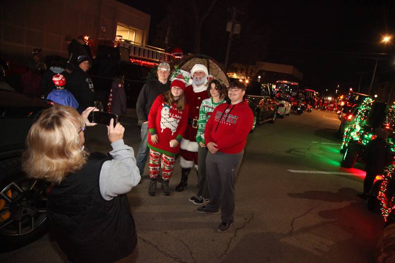Santa poses with a family at the Annual Lighted Holiday Parade in Downtown Morris on Friday.