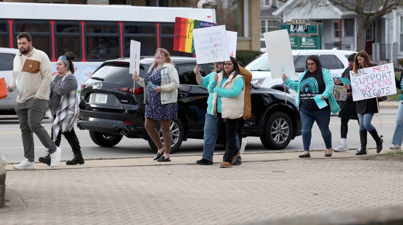 Marchers walk by traffic on First Street Monday, April 7, 2025, during the Safe Passage Take Back the Night and Survivor Speak Out in Dekalb. The event is held in conjunction with Sexual Assault Awareness Month.
