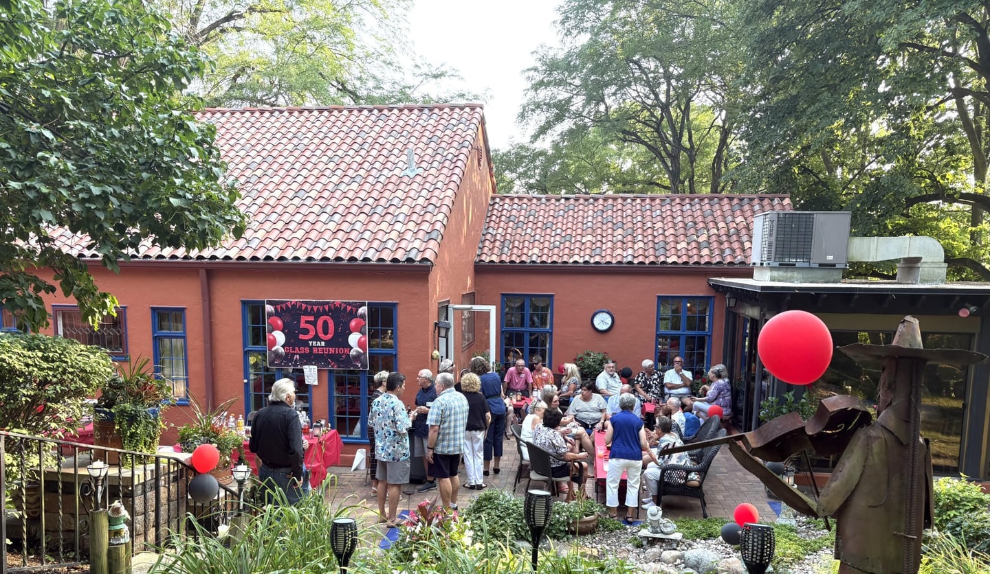 Classmates from Marseilles High School’s Class of 1975 socialize in Seattle Sutton’s backyard during their 50-year reunion celebration.