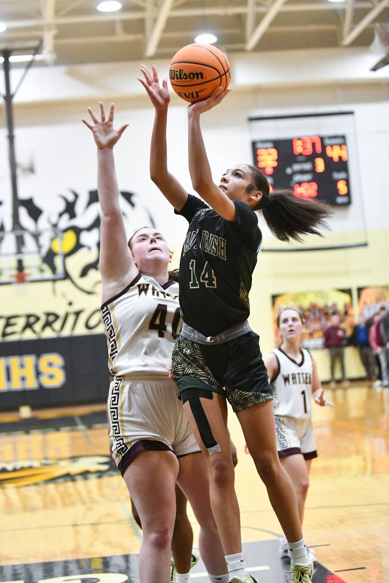 Bishop McNamara's Jaide Burse hits a layup past Watseka-Milford's Megan Martin during the Fightin' Irish's 69-38 victory over Watseka-Milford in the IHSA Class 2A Herscher Sectional championship on Thursday, Feb. 27.