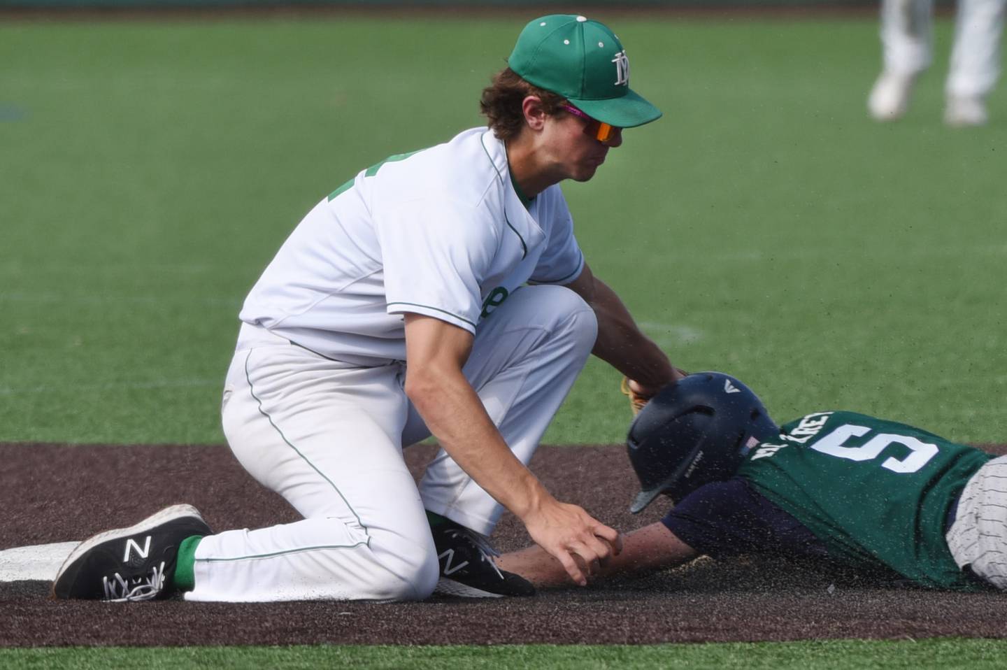 Joe Lewnard/jlewnard@dailyherald.com
York shortstop Josh Fleming tags out New Trier’s Jackson McCarey at second base during the Class 4A state third-place baseball game in Joliet Saturday.