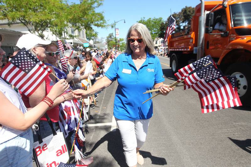 Village Clerk Gigi Radcliffe hands out American flags Monday, May 29, 2023, on Main Street during the Wauconda Memorial Day Parade.