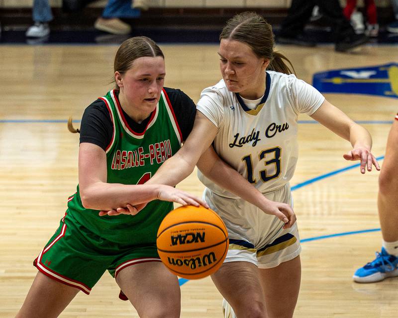 Alexus Hines (4) of LaSalle-Peru dribbles ball near top of key whilst Emily Adair (13) of Marquette reaches across body in attempt to steal ball on Saturday, January 3, 2026 at Marquette Academy in Ottawa.
