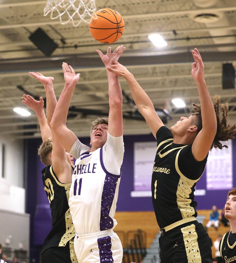 Rochelle's Brody Bruns goes to the basket between a pair of Sycamore defenders Friday, Dec. 5, 2025, during their game at Rochelle High School.