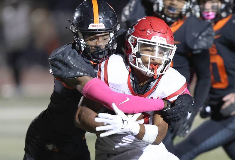 DeKalb's LaBrian Carrington wraps up Naperville Central's Caleb Brown during their game Friday Oct. 7, 2022, at DeKalb High School.