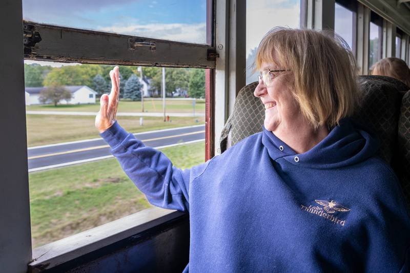 Patti Lambert of Putnam waves out train window during train ride on Saturday, September 28, 2024 in Bureau.