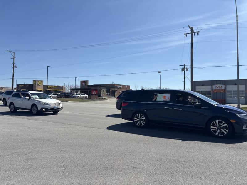 Cars hold signs in support at a No Kings rally in Crystal Lake, Saturday, March 28, 2026.