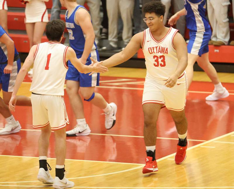 Ottawa's Carson Keylard hi-fives teammate Colt Bryson during the Dean Riley Shootin' The Rock Thanksgiving Tournament on Monday Nov. 24, 2025 in Kingman Gymnasium at Ottawa High School.