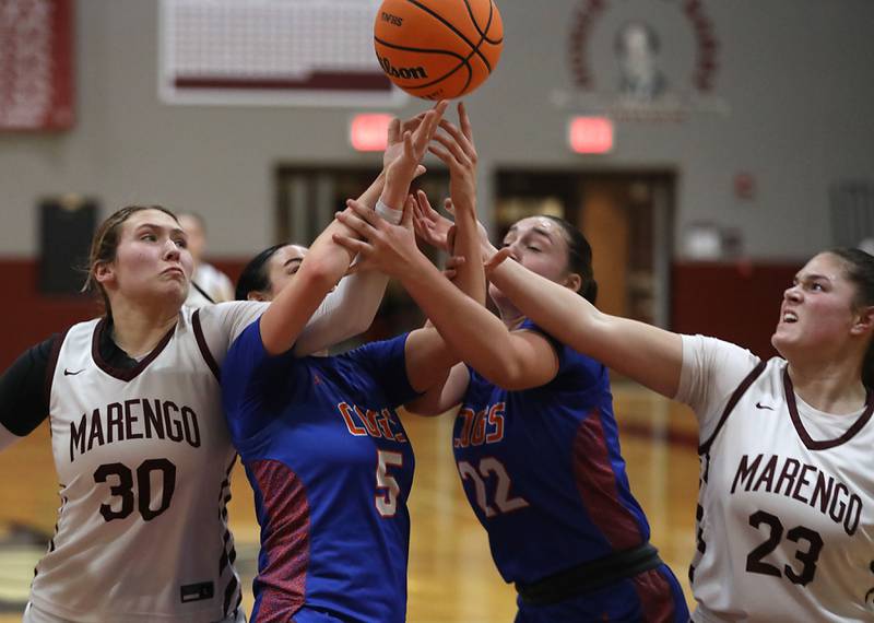 Marengo's Macy Noe, (left) Genoa-Kingston's Zoe Boylen, (center left) battles with Marengo's Gianna Iovinelli (right) and Genoa-Kingston's Regan Creadon (center right) for a rebound during an IHSA Class 2A Marengo Regional semifinal girls basketball game on Monday, Feb. 16, 2026, at Marengo High School.