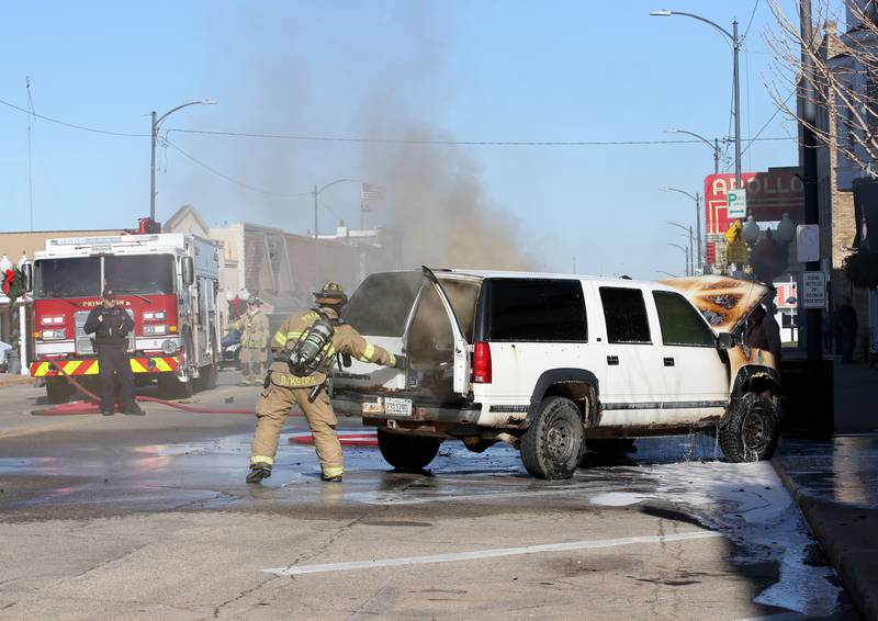 Princeton firefighter Nick Dykstra opens the back door of a GMC Suburban to vent out the smoke after it caught fire in the 500 block of South Main Street on Monday, Nov. 21, 2022 in Princeton.