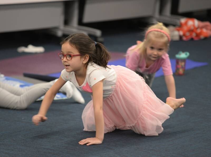 Children including Frida Johnson pretend to be bears while participating in Earth Day Yoga at La Grange Park Library Sunday April 13, 2025. The event was held to celebrate Earth Day.