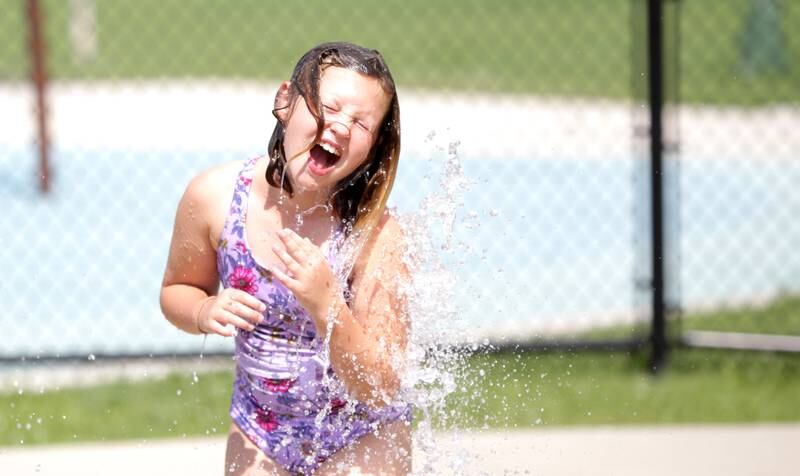 Nine-year-old Essie Amara of Lombard plays in the water at the Gordon Park Splash Pad in La Grange as temperatures hit the 90s on Friday, July 28, 2023.