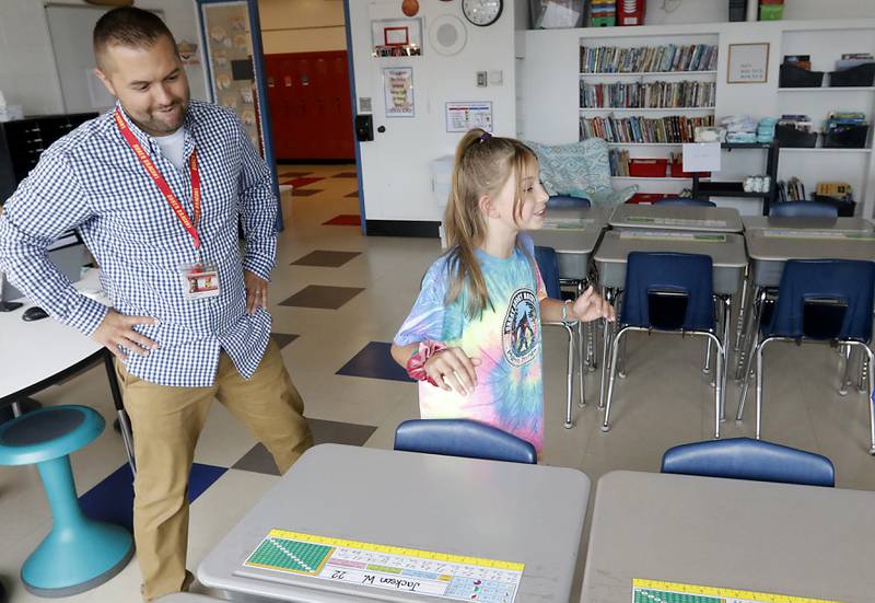 Briella Gianesin, 9, a fourth grader at Duker Elementary School in McHenry, excitedly looks for her desk on Tuesday, Aug. 15, 2023, during school supplies drop-off day, as her teacher, Jon Schwalenberg, watches.