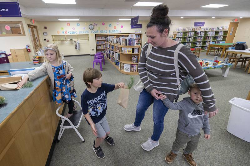 The Gomes family Emmilyn, 5, Tucker 7, Kassey and Quinton, 2, pick up their saplings Monday, April 22, 2024 at the Dixon library. Neighborhood Forrest is giving away the trees to kids so they can watch and nurture the trees but it helps beautify the neighborhood and reduce the carbon footprint.