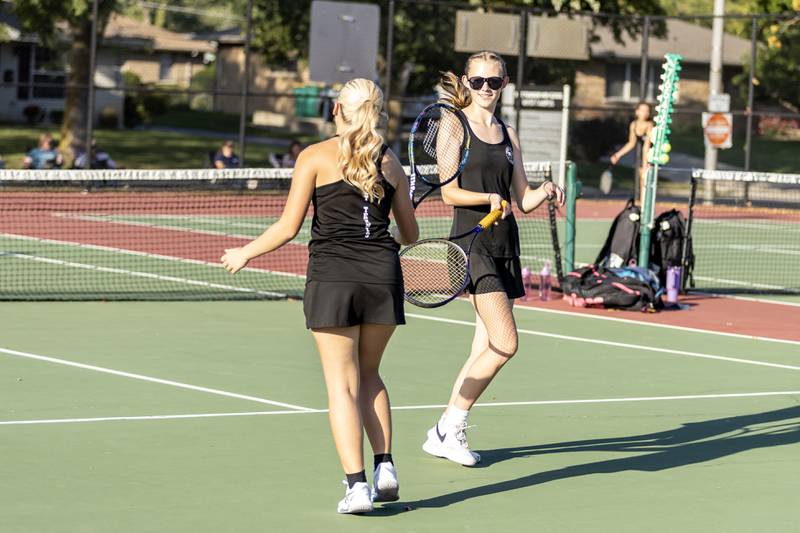 Isa Hebrard and Elena Yanchick celebrate scoring a varsity doubles tennis point during a match against Joliet Catholic at Joliet West on Sept. 29, 2025.