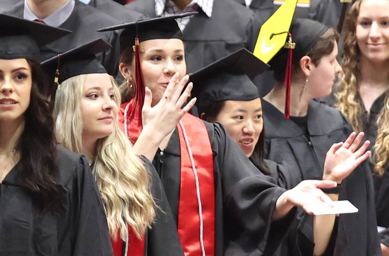 A student blows kisses to her family as she heads to her seat Saturday, May 14, 2022, during the first of two undergraduate commencement ceremonies at Northern Illinois University in DeKalb.
